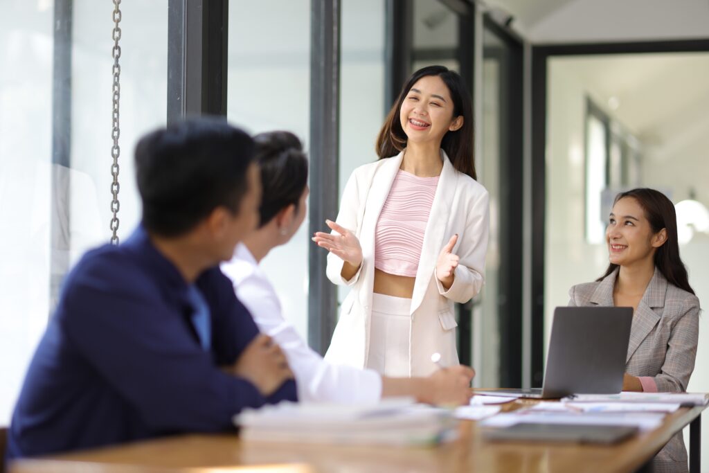 A young employee discussing in front of her colleagues, showing her leadership potential.